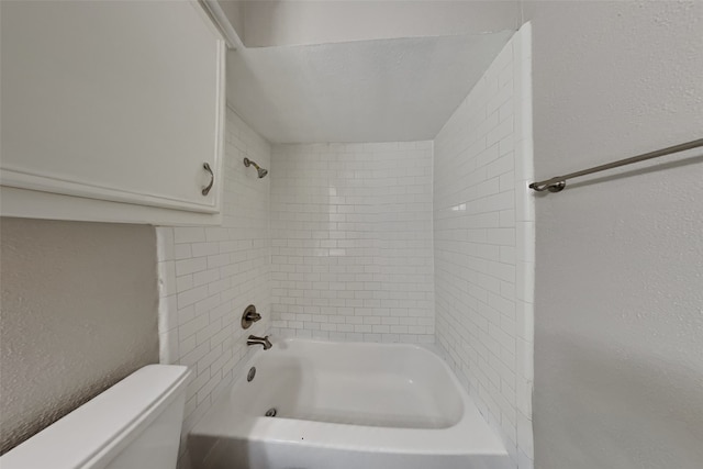 bathroom with tiled shower / bath combo and toilet