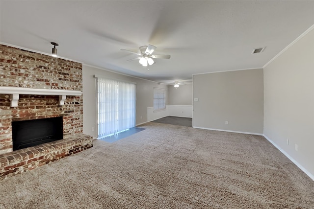 unfurnished living room with ceiling fan, carpet flooring, ornamental molding, and a fireplace