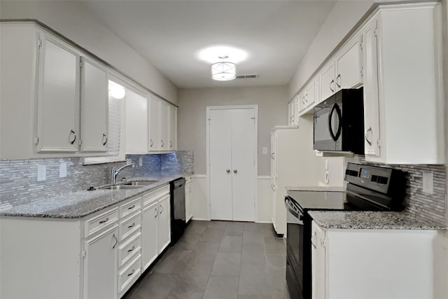 kitchen with light stone counters, sink, black appliances, and white cabinets