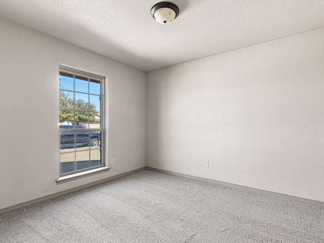 unfurnished room with carpet flooring and a textured ceiling