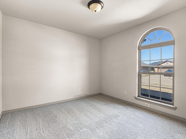 carpeted spare room with a textured ceiling