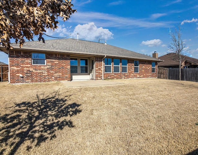 back of property with a yard and a patio area