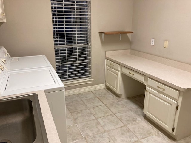 laundry area featuring light tile patterned floors, washer and clothes dryer, and cabinets