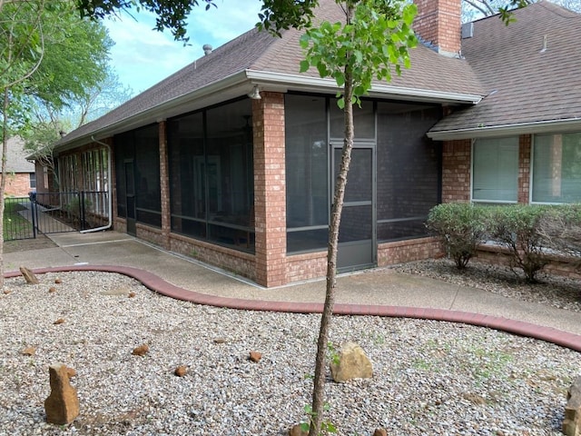 view of property exterior featuring a patio area and a sunroom