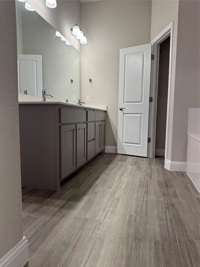 bathroom featuring a bath, vanity, and hardwood / wood-style floors