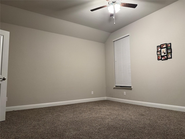 empty room with vaulted ceiling, ceiling fan, and dark colored carpet