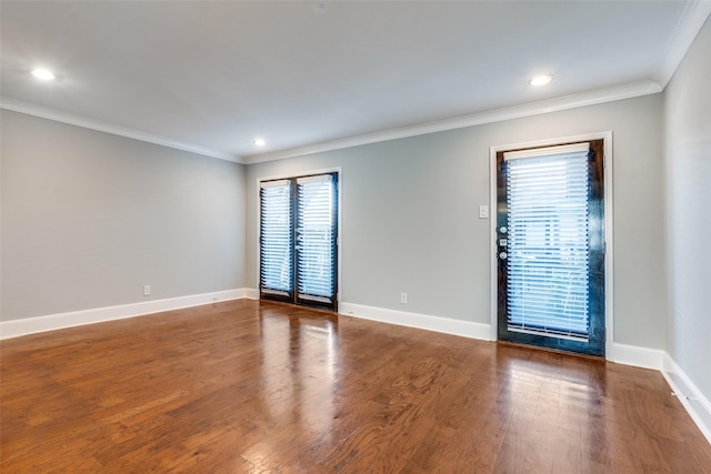 empty room featuring crown molding and dark hardwood / wood-style flooring