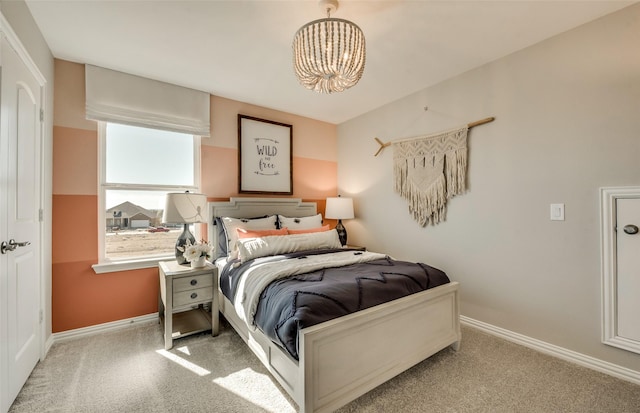 bedroom featuring an inviting chandelier and light carpet