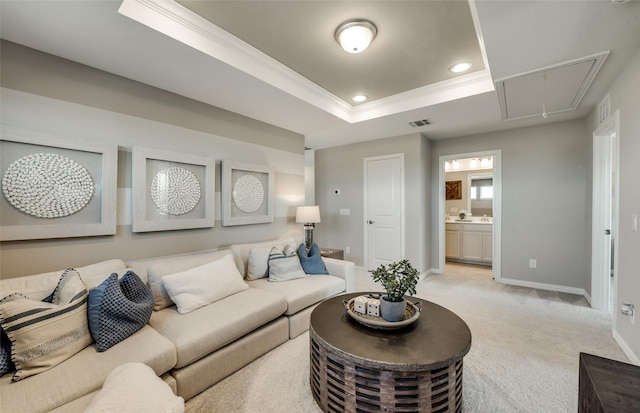 living room featuring ornamental molding, light colored carpet, and a tray ceiling