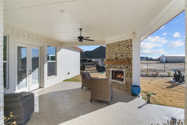 view of patio / terrace with ceiling fan and an outdoor stone fireplace