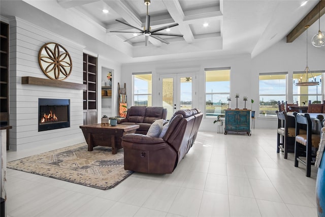 living room featuring an inviting chandelier, a fireplace, beam ceiling, and a towering ceiling