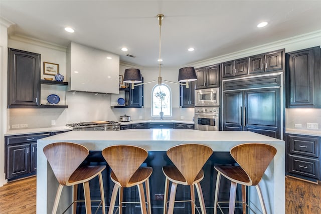 kitchen featuring dark hardwood / wood-style flooring, built in appliances, a center island, and range hood