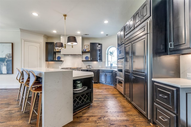 kitchen featuring ornamental molding, decorative light fixtures, a center island, and custom exhaust hood