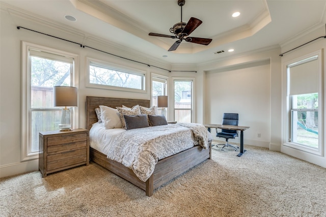 carpeted bedroom with multiple windows, crown molding, a raised ceiling, and ceiling fan