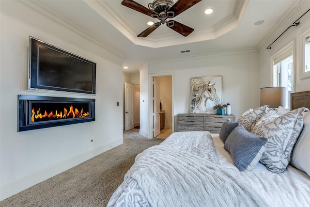 bedroom with ornamental molding, light carpet, ceiling fan, and a tray ceiling