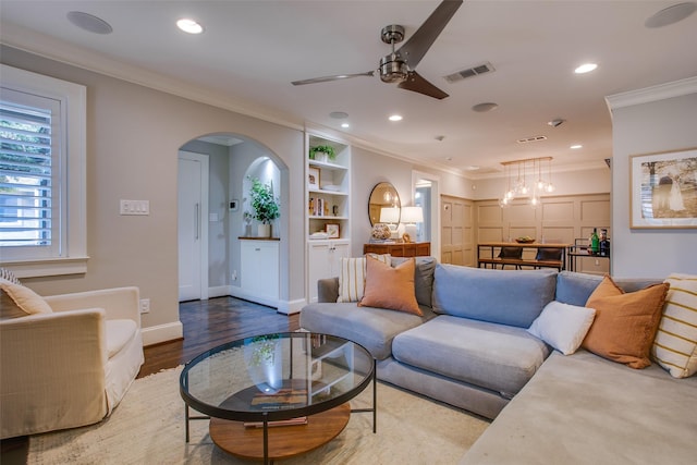 living room with ornamental molding, ceiling fan, light hardwood / wood-style floors, and built in shelves