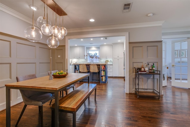 dining room with sink, dark wood-type flooring, and ornamental molding