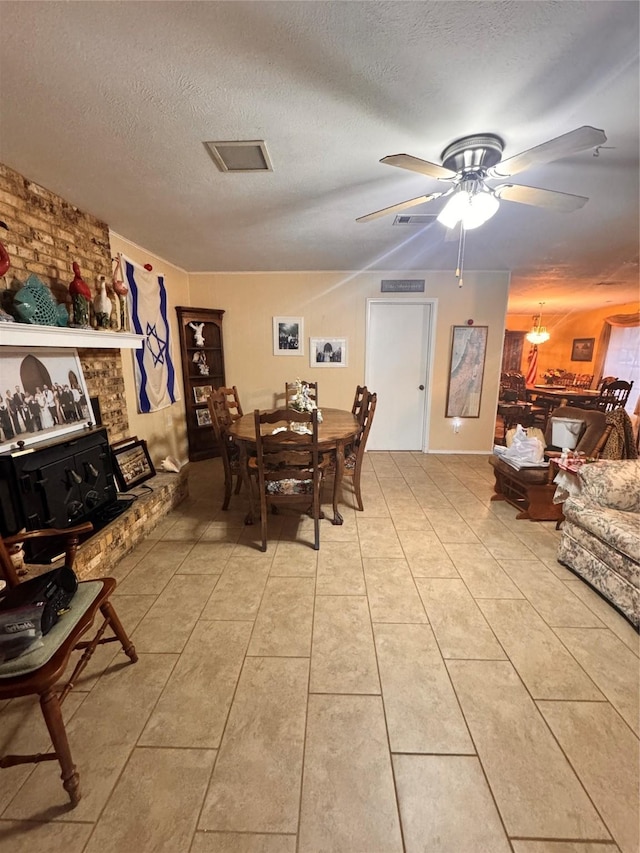 tiled dining area featuring ceiling fan and a textured ceiling