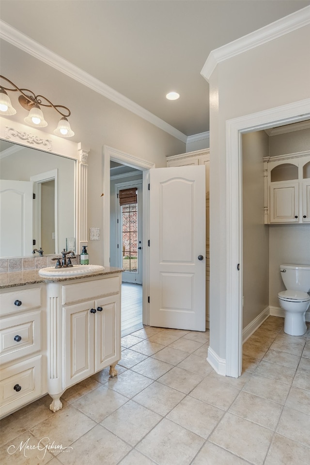 bathroom featuring vanity, tile patterned flooring, crown molding, and toilet