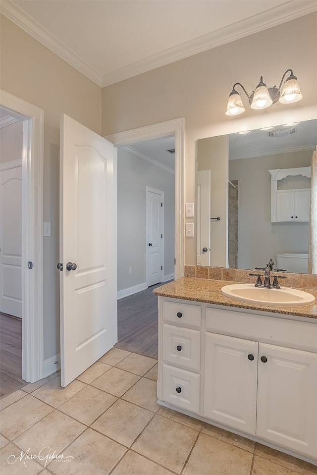 bathroom with tile patterned flooring, vanity, ornamental molding, toilet, and walk in shower