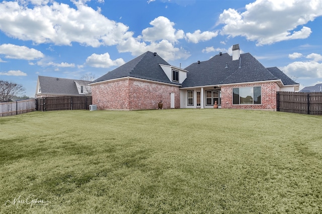 rear view of house featuring a yard