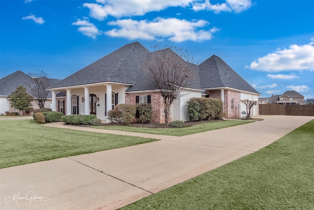 french provincial home featuring a front lawn and covered porch