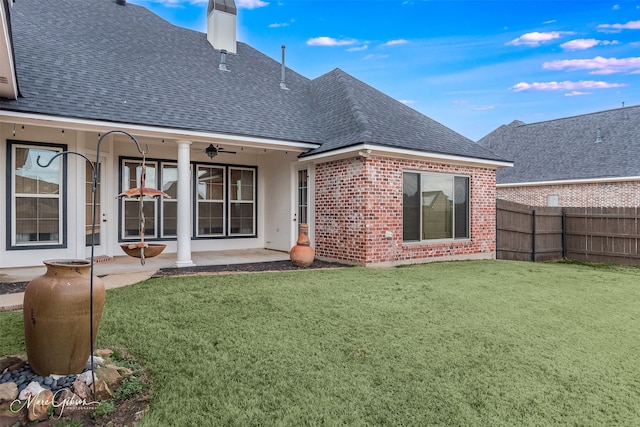 rear view of property featuring a patio and a lawn