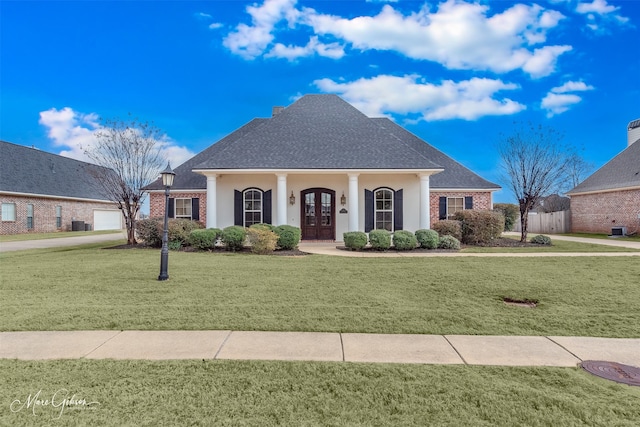 view of front of home with central AC unit and a front yard