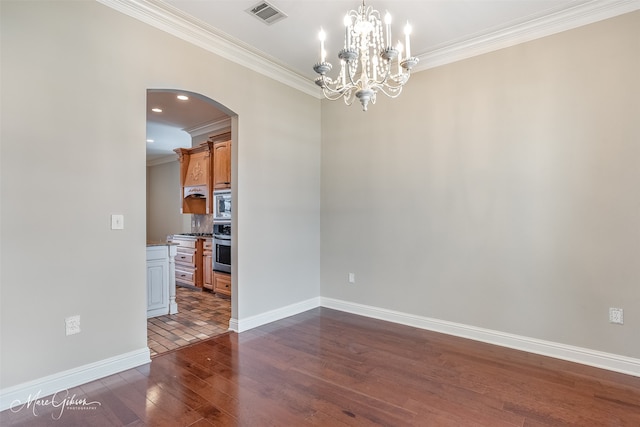 empty room with dark wood-type flooring, crown molding, and an inviting chandelier