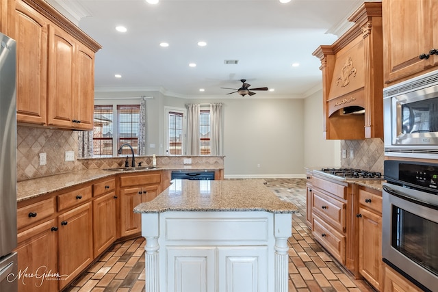 kitchen featuring sink, appliances with stainless steel finishes, a center island, light stone counters, and ornamental molding