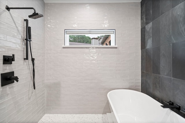 bathroom with tile walls and separate shower and tub