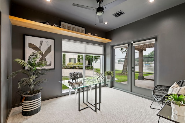 carpeted home office with ceiling fan and a healthy amount of sunlight