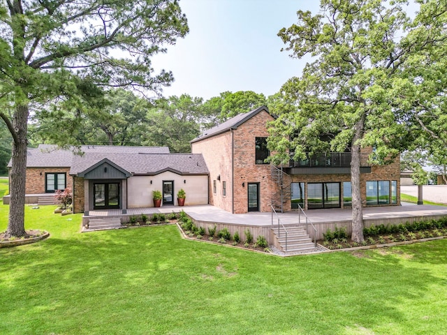 rear view of property with french doors, a wooden deck, and a lawn