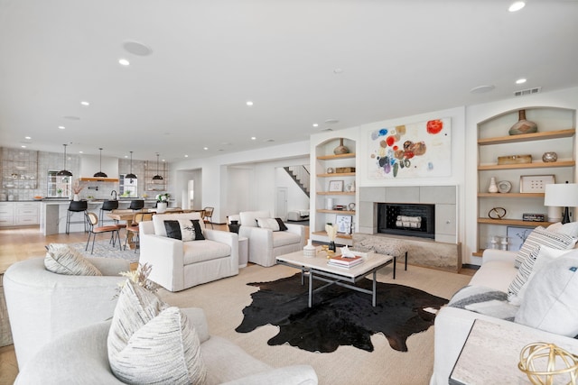 living room featuring light hardwood / wood-style flooring and built in shelves