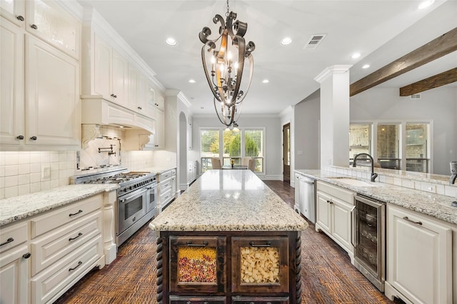 kitchen featuring sink, appliances with stainless steel finishes, white cabinetry, a center island, and wine cooler