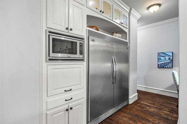 909 Reflection Ct, Heath, TX 75032 - kitchen featuring built in appliances, ornamental molding, glass insert cabinets, white cabinetry, and baseboards