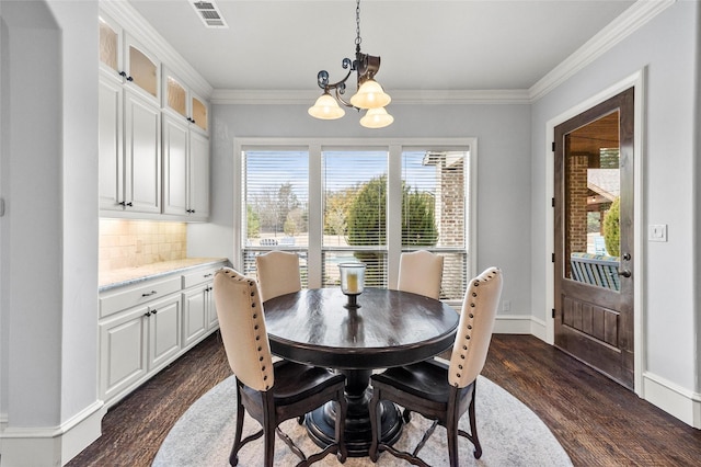 dining area with ornamental molding, dark hardwood / wood-style floors, and a chandelier