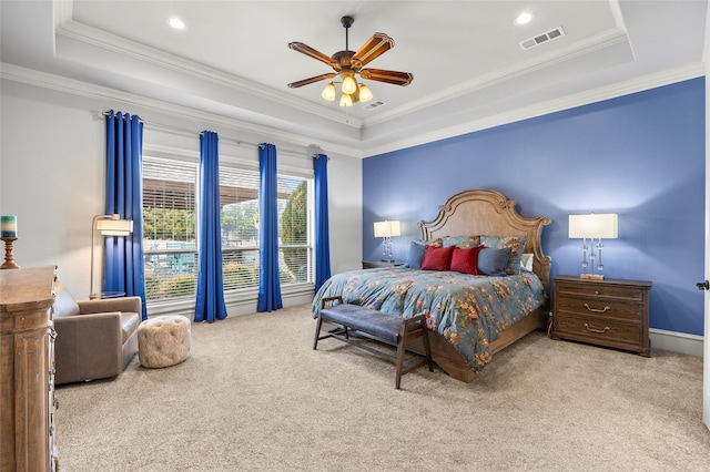 carpeted bedroom with a raised ceiling, crown molding, and ceiling fan