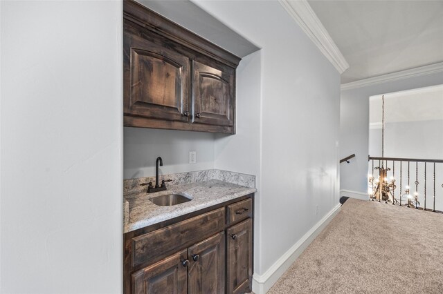 bar with sink, crown molding, dark brown cabinets, and carpet flooring