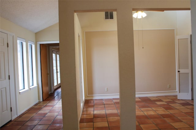 tiled foyer with lofted ceiling and a textured ceiling