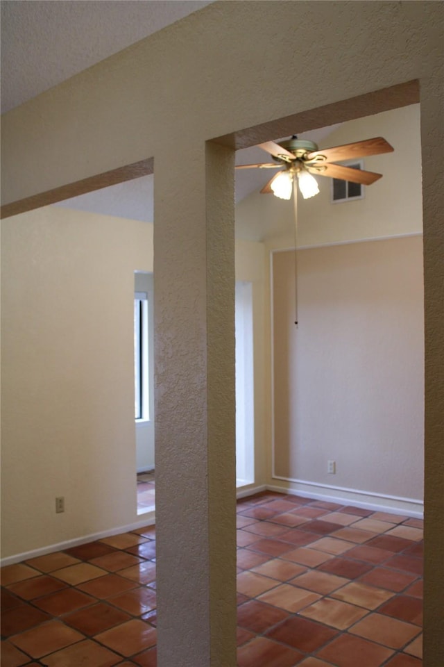 tiled spare room featuring ceiling fan