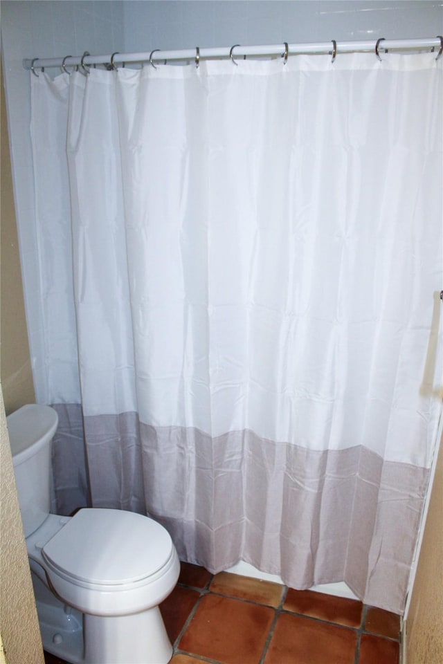 bathroom featuring toilet and tile patterned flooring