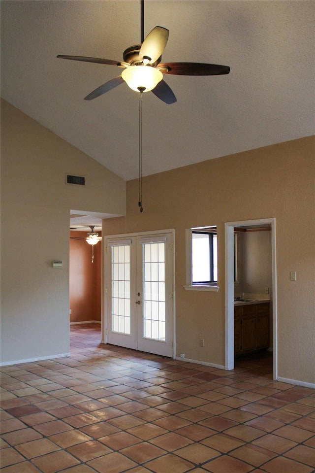 empty room with sink, ceiling fan, dark tile patterned floors, high vaulted ceiling, and french doors