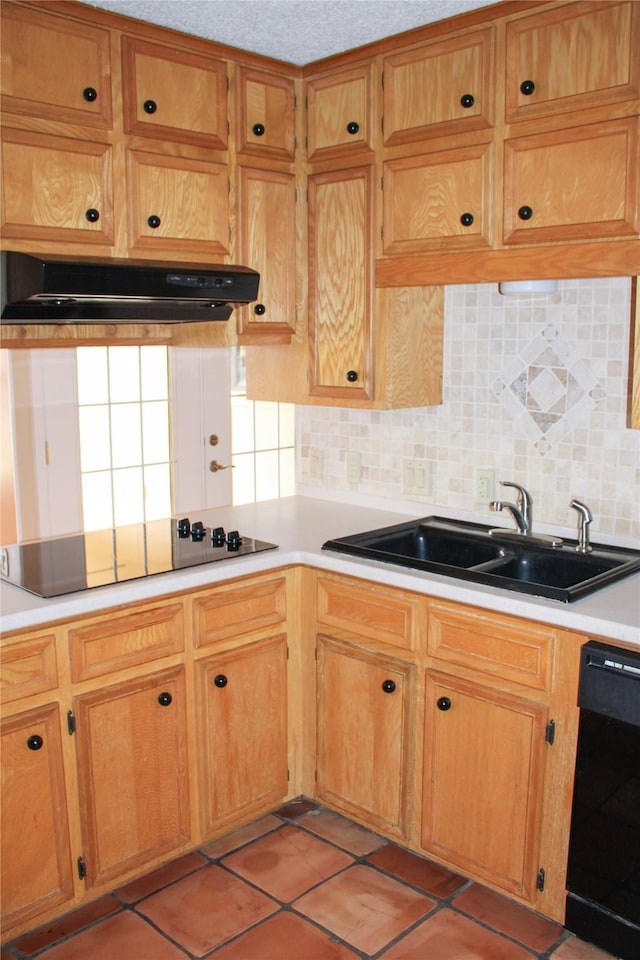 kitchen with sink, light tile patterned floors, black appliances, a textured ceiling, and decorative backsplash