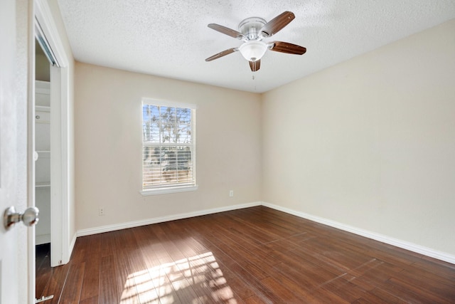 spare room with ceiling fan, dark wood-type flooring, and a textured ceiling