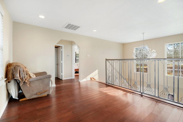 living area featuring dark hardwood / wood-style flooring and a chandelier