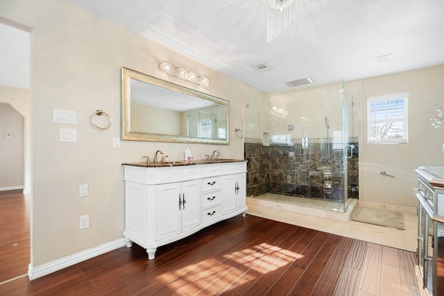 bathroom with vanity, wood-type flooring, and a tile shower