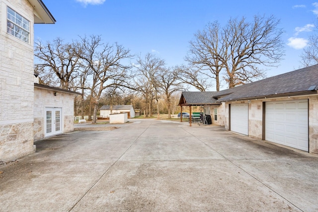 view of patio with french doors, a storage shed, and a garage