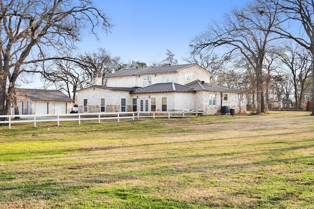 back of house with cooling unit, a garage, and a lawn