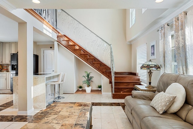 living room with ornamental molding and a high ceiling